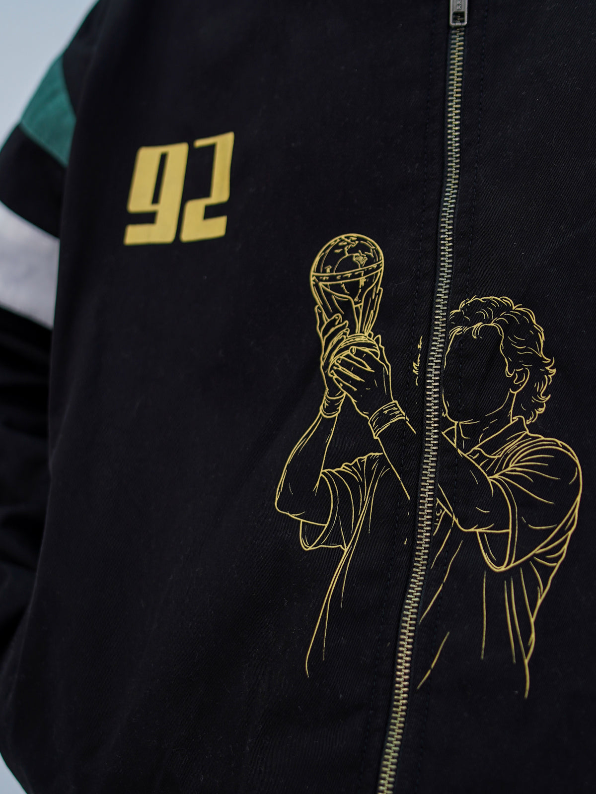 Cornered Tigers '92 jacket — close-up of gold 92 and trophy-lift screen print split by the zip